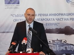 a man standing at a podium with microphones
