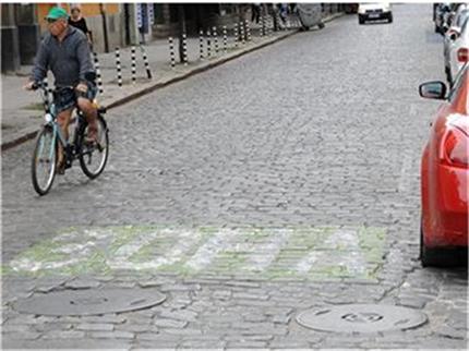 a man riding a bicycle on a cobblestone street
