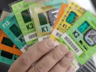 a hand holding a group of colorful tickets