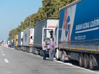 a group of men standing next to trucks