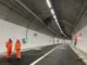 a group of men in orange uniforms in a tunnel