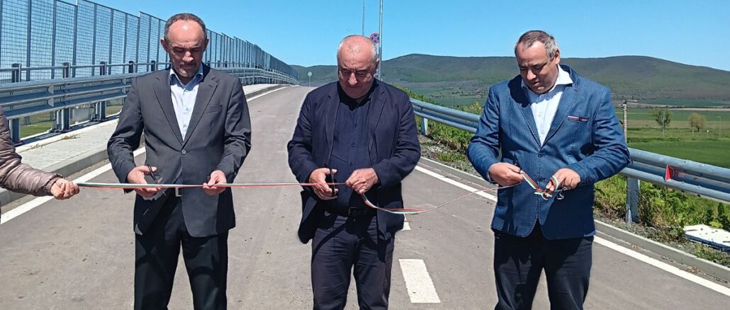 a group of men standing on a road with a red tape