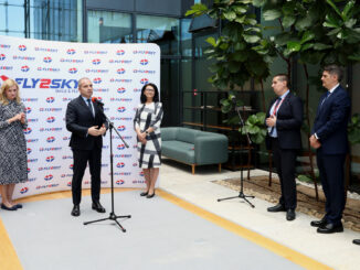 a group of people standing in front of a wall with microphones