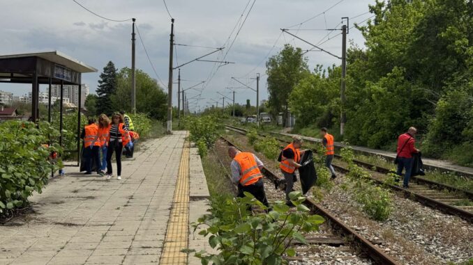 a group of people in orange vests on train tracks